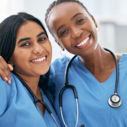 Doctors, selfie and women friends at hospital smile for photograph together with stethoscope. Happy, healthcare and interracial friendship picture of professional cardiology workers on break.